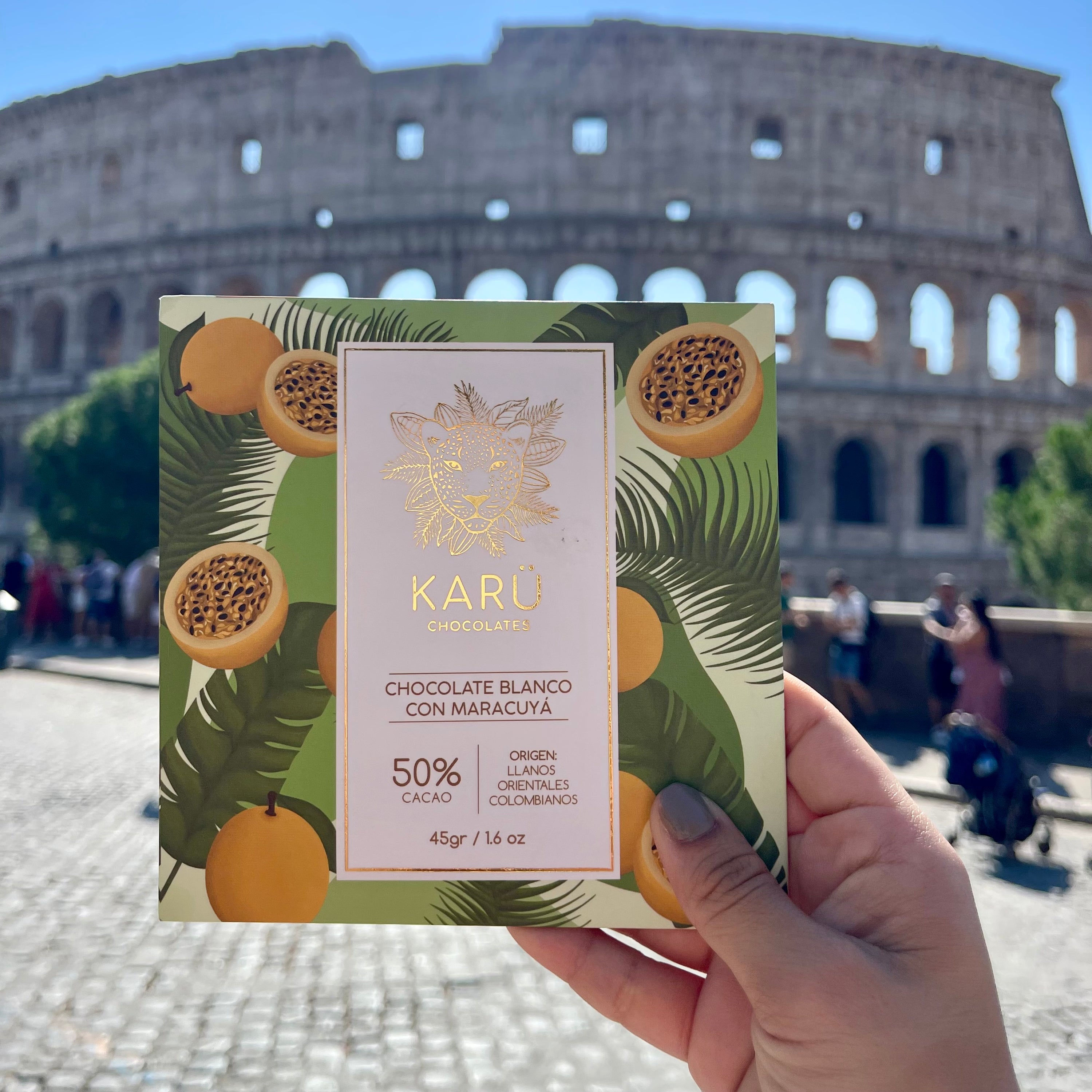 Hand holding a Karu chocolate bar with the Colosseum in the background